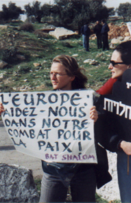Members of Bat Shalom hold up signs in demonstration at Har Homa