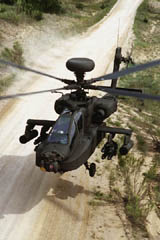 Boeing Apache Longbow helicopter hovering over a dirt road - Click for audio